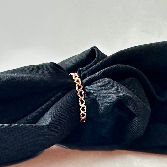 Rose gold ring on a black fabric background