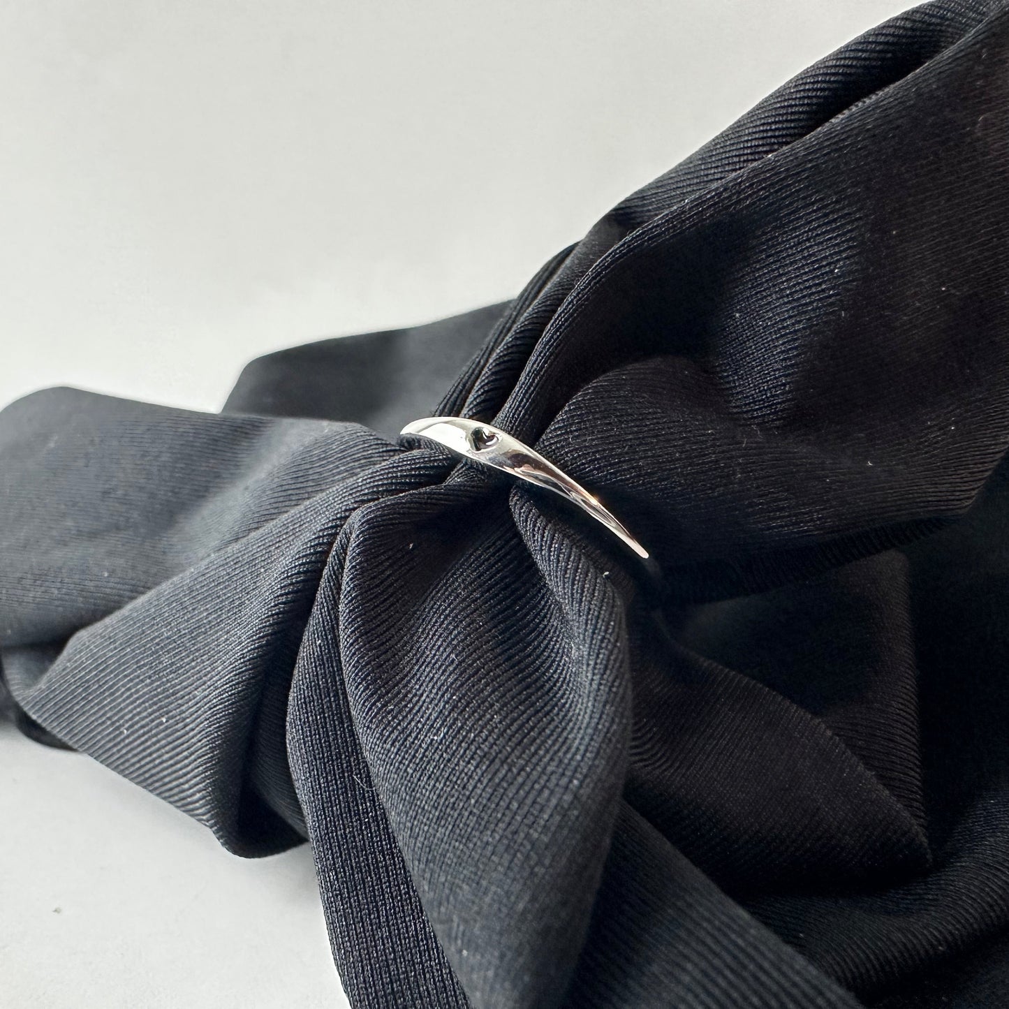 Black fabric with a silver ring on a white background
