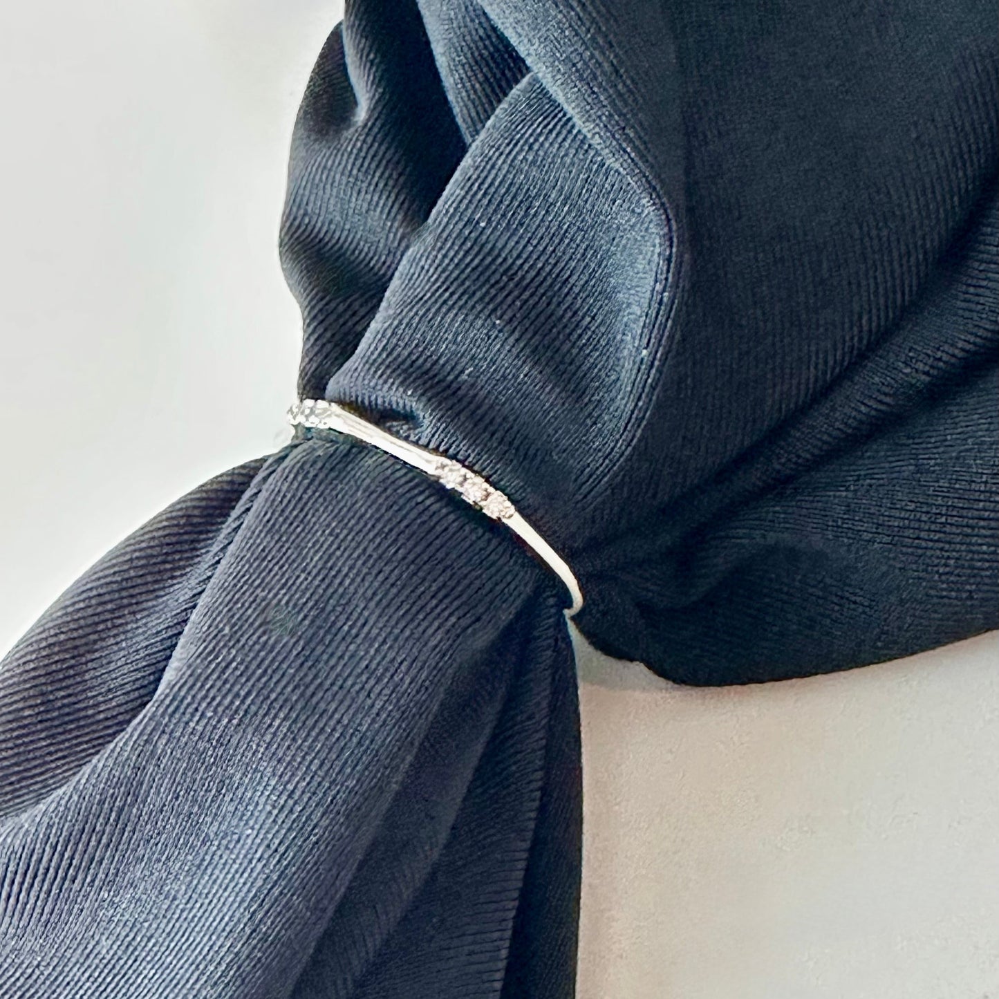 Navy blue fabric with a silver ring on a white background