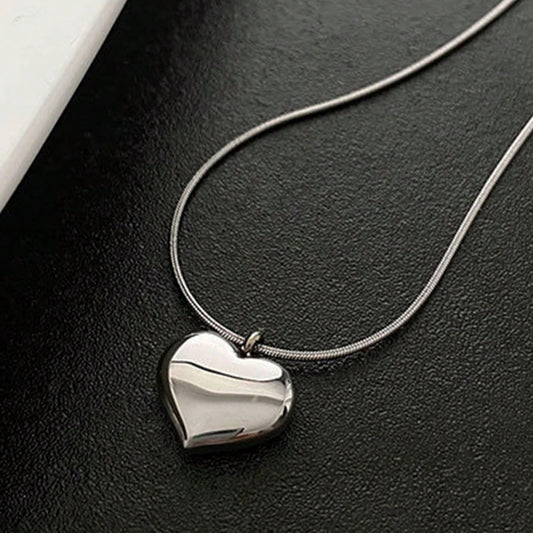 Silver heart-shaped pendant necklace on a dark surface