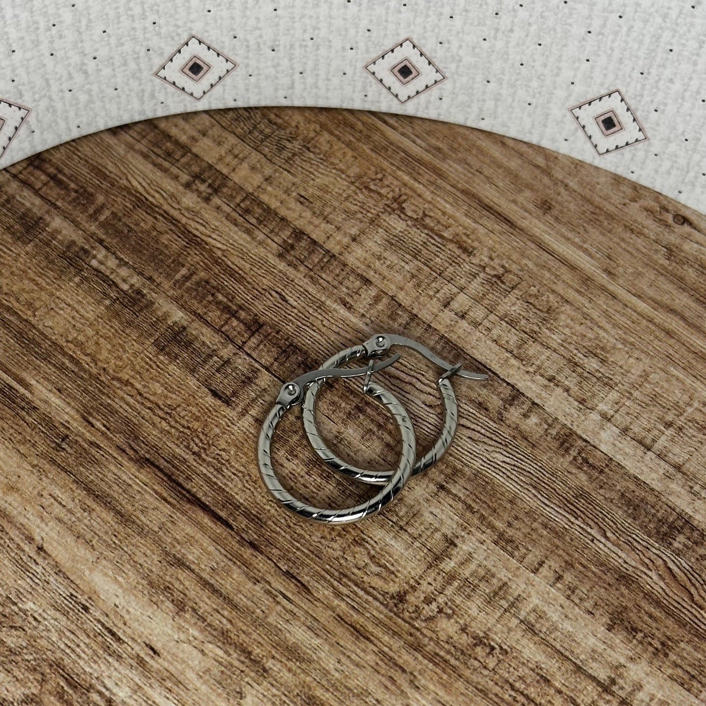 Wooden cutting board with two rings on a patterned surface