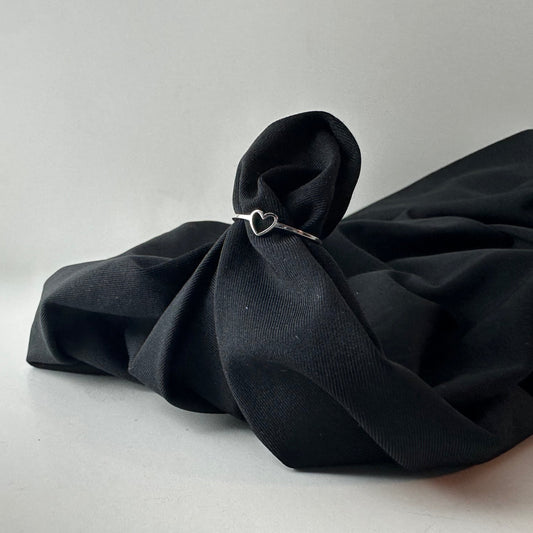 Black fabric with a heart-shaped ring on a white background