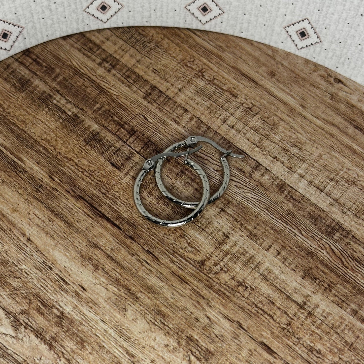 Wooden cutting board with two rings on a patterned surface