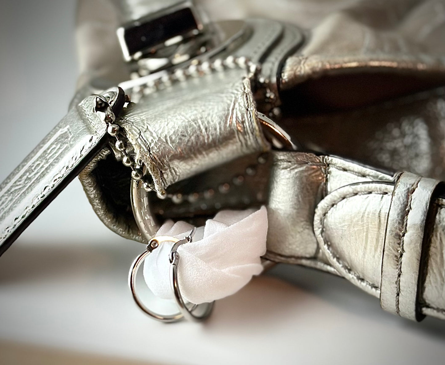 Close-up of a silver set of earrings on a white fabric on a light background