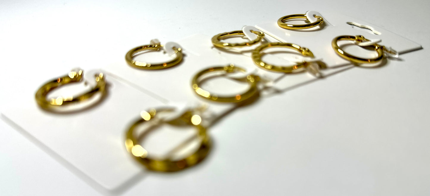 Set of gold hoop earrings on a white background